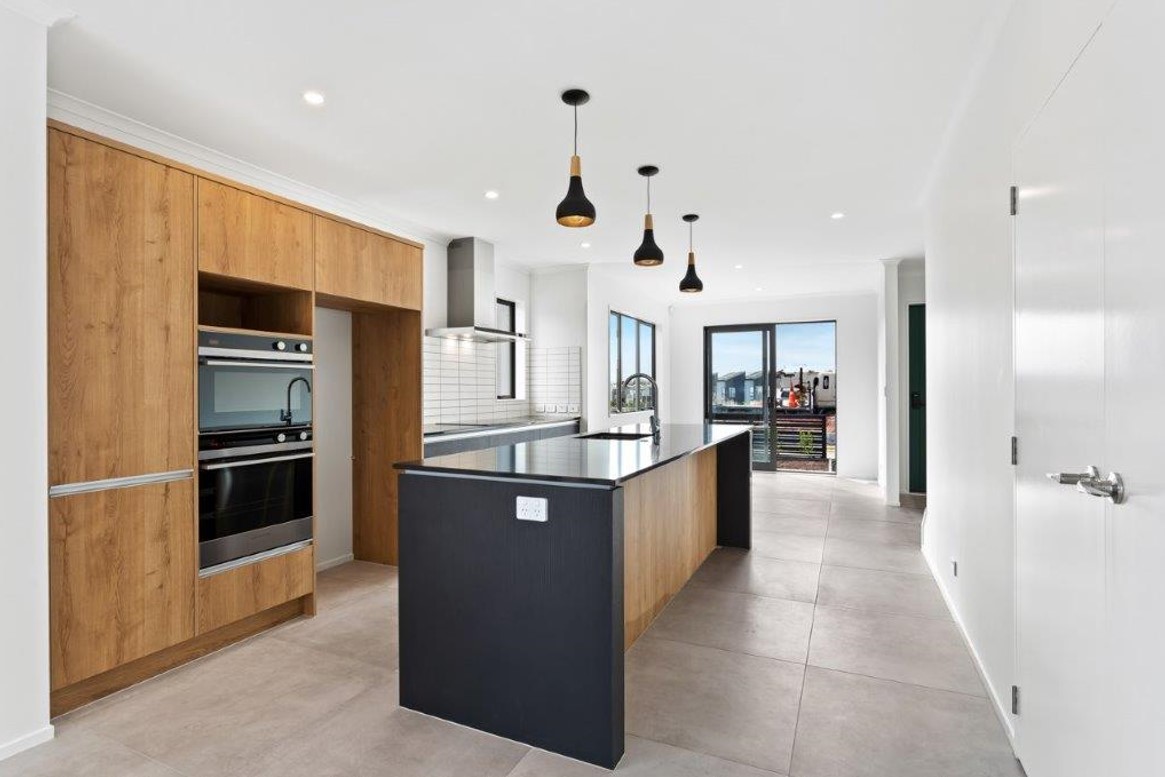 Modern kitchen with wood paneling and black granite island bench